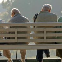 Rentner sitzen auf einer Parkbank.
