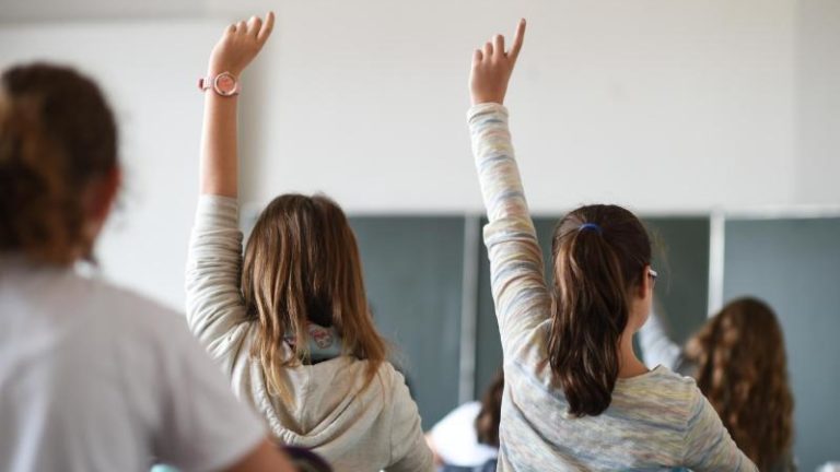 Schüler melden sich während des Unterrichts in einem Gymnasium